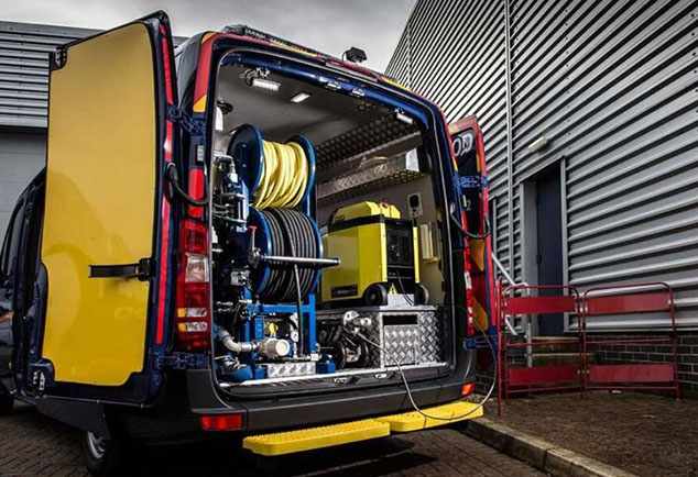 Servicebus van de loodgieter met hogedrukslangen en ontstoppingsapparatuur